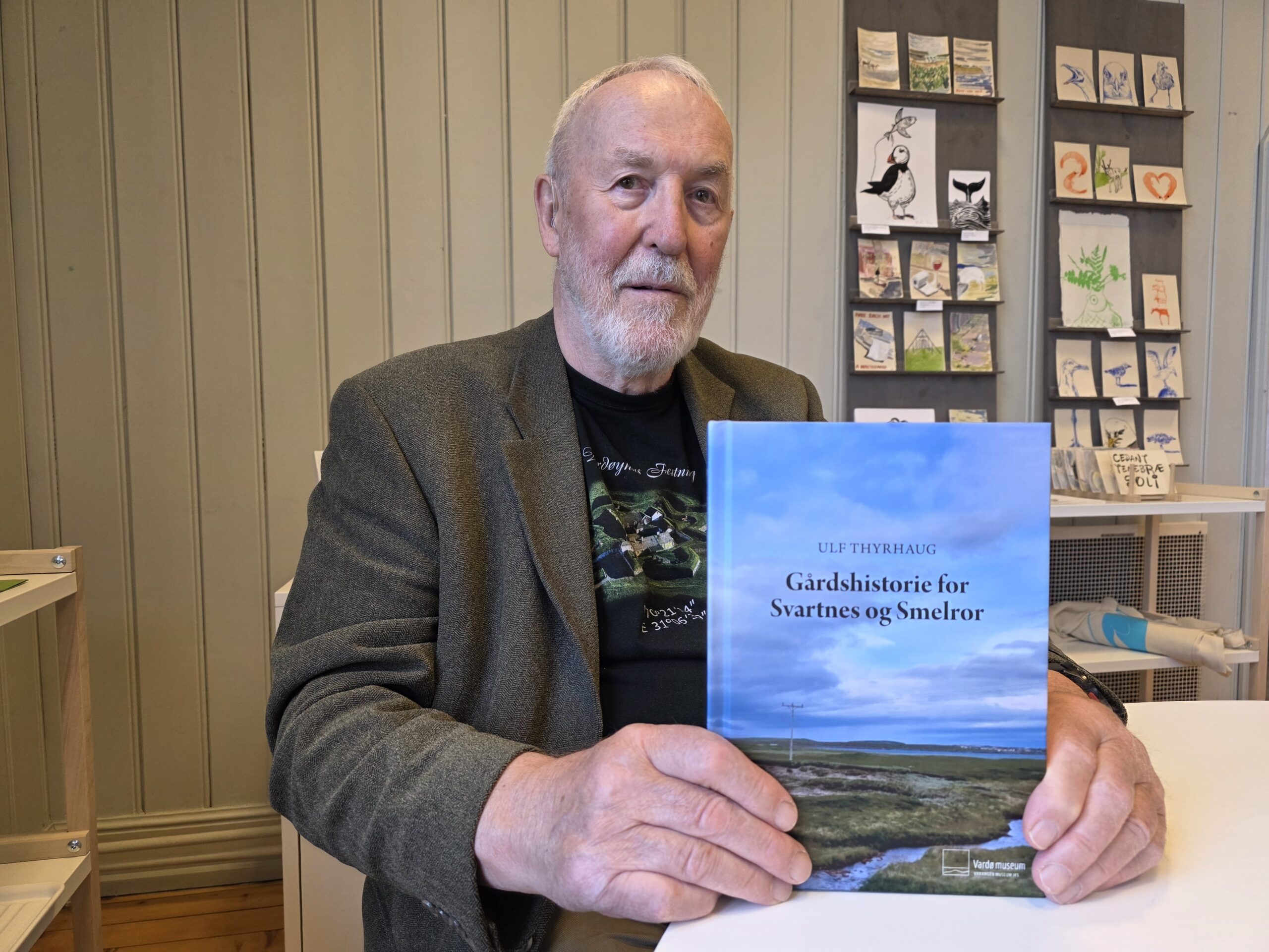 Etter at Ulf Thyrhaugs bokpresentasjon er over, finner vi forfatteren sitte og signere boken sin. Hver tredje som kom til Thyrhaugs foredrag denne dagen forlot Vardø museum etter å ha kjøpt boka hans. Ulf Thyrhaug har bakgrunn som lærer. Det er som pensjonist han har funnet tid til å grave i gårdshistorien for Svartnes og Smelror. Vi får ham til å fortelle om hvordan bokprosjektet begynte. – Det var i 2020 at Thorleif Isaksen, Trygg Olsen og jeg satt hjemme hos meg på Svartnes idéen ble unnfanget. Dette var livet mitt i fem år. Jeg har i det hele kost meg, oppsummerer Ulf. Thorleif skulle samle inn fotografier, mens han skulle ta meg av det skriftlige. Ulf legger ikke skjul på at det var utfordrende å få tak i bilder fra bygdene. Lovnader ble ikke fulgt opp. Dette nevnte Ulf også syrlig i sitt foredrag. Særlig savner forfatteren bilder fra Svartnes før krigen. Der har han kun ett bilde selv, men flere tatt etter krigen. Han tror bilder finnes hos familier som flyttet og tok bildene med seg. Så spør vi hva han sitter igjen med av inntrykk etter at produktet er levert. Tragedier – Det var mye som var nytt for meg. Tragedier som egentlig ikke overrasket. Men at så mange druknet ga refleksjoner. På Svartnes druknet tippoldefaren min da han var gift med ei enke, der hennes første mann også hadde omkommet som følge av drukning, forteller Thyrhaug. Han forteller om et annet tilfelle der seks karer fra Smelror og to fra Svartnes hadde vært på fest i Vardø. På veg hjem omkom alle sammen. Den sterke strømmen i Bussesundet i kombinasjon med dårlig vær og alkohol i kroppen, førte til en tragedie for de to fastlandsgårdene. – Tragedien har berørt mange siden de alle var unge familiefedre. Det var tøft, sier Ulf. Den vanskeligste delen av arbeidet var å lese de gamle håndskrevne protokollene. Dette fikk han hjelp til av museet. Men på noen punkter slet selv de, forteller han. Forfatteren er takknemlig for betydelig korrektur og tekstveiledning fra konservator Isa Maline Isene. Ulf Thyrhaug har vært inne på tanken om å skrive gårdshistorien for Persfjord og Sandfjord, men synes det blir vanskelig uten matrikkelkart. Forøvrig skal en utflyttet vardøværing jobbe med gårdshistorien for Kiberg. Sjefen for Vardø museum gir honnør for arbeidet som nå er sluttført. – Det er en formidabel mengde informasjon som er dokumentert. Vi er veldig takknemlige for Ulf Thyrhaugs innsats. Vi vil gjøre det vi kan for å få dette formidlet best mulig, sier Inger Lene Nyttingnes avslutningsvis.
